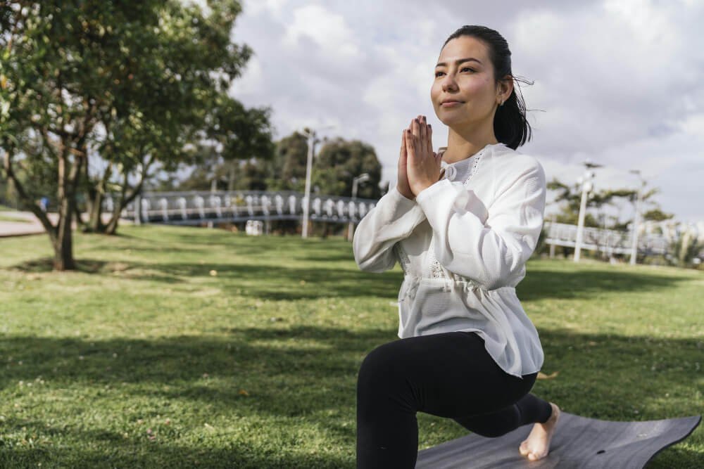 mulher praticando exercício ao ar livre de relaxamento muscular
